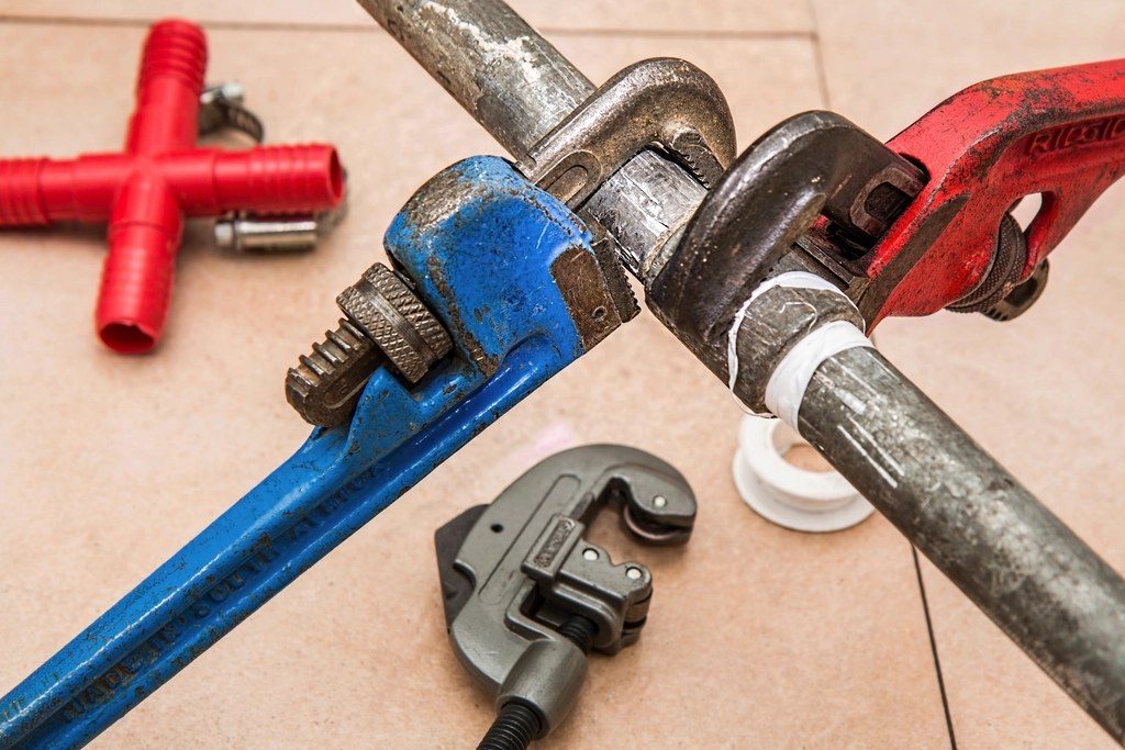 Pipe wrenches gripping a steel pipe